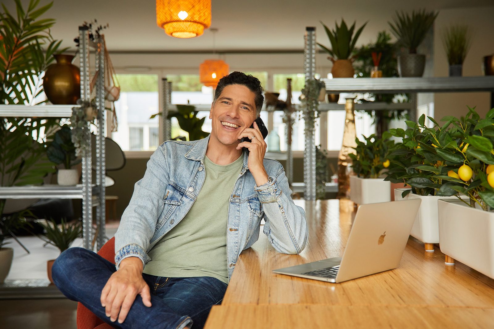 Coach d’anglais pro – English for Life Coach d’anglais English for Life souriant au téléphone, assis à son bureau avec un ordinateur portable
